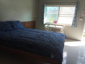Un dormitorio con una cama y una ventana y una mesa. en boomhousehotel, en Chiang Khong