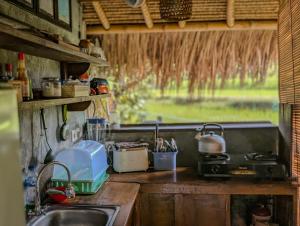 a kitchen with a sink and a counter top at Cute Eco Cottage Near 7 Waterfalls in Singaraja