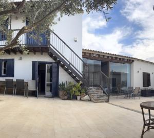 a patio with a staircase leading up to a house at The Family Nest - Traditional Serenity in Orounda +6 photos