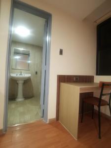 a bathroom with a sink and a desk with a chair at Hotel San Francisco Centro Histórico in Mexico City