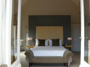1 dormitorio con 1 cama grande y 1 silla en Four Rosmead Boutique Guesthouse en Ciudad del Cabo