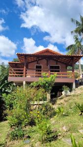 una casa con techo de madera en un campo en Casa charmosa no centro de São Pedro da Serra, en Nova Friburgo