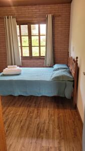 una cama grande en una habitación con ventana en Casa charmosa no centro de São Pedro da Serra, en Nova Friburgo 30 fotos más