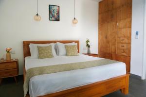 a bedroom with a large bed and a wooden cabinet at Tranquil 2BR Pool Villa - Fast WiFi - Work-Friendly - Near Echo Beach in Tumbak Bayuh +44 photos