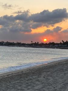 einen Sonnenuntergang am Strand mit dem Meer in der Unterkunft Serrambi Paradise in Porto De Galinhas