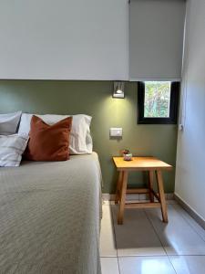 a bedroom with a bed and a wooden table at Loft Los Cerezos en VISTALBA, zona de viñedos y bodegas in Ciudad Lujan de Cuyo