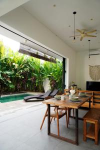 a dining room with a table and a large window at Tranquil 2BR Pool Villa - Fast WiFi - Work-Friendly - Near Echo Beach in Tumbak Bayuh