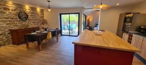a kitchen and dining room with a table and chairs at Maison entièrement rénovée, jardin & terrasse à 5min des plages in Combrit