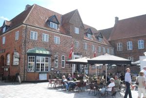 un grupo de personas sentadas en mesas frente a un edificio en Hotel Dagmar en Ribe