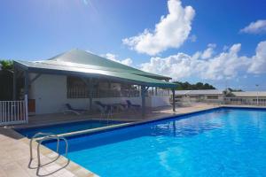 a large blue swimming pool with a pavilion at O Ti Pozé in Pointe-à-Pitre