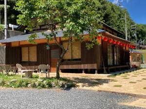 京都cafe & guesthouse 魚ヶ淵的前面有一棵树的建筑物