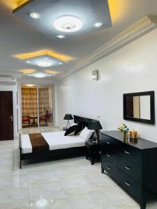 a bedroom with a bed and a flat screen tv at Mayna House in Dakar