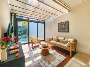 ein Wohnzimmer mit Sofa und Tisch in der Unterkunft Silk Umalas by Nagisa Bali in Kerobokan