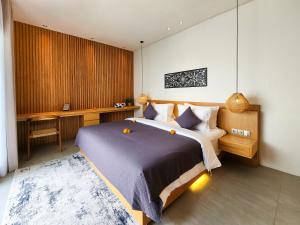 ein Schlafzimmer mit einem großen Bett und einem Schreibtisch in der Unterkunft Silk Umalas by Nagisa Bali in Kerobokan + 60 Fotos