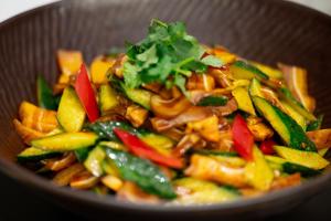 a bowl of food with peppers and other vegetables at 西安明城墙永兴坊桔子水晶酒店 in Xi'an