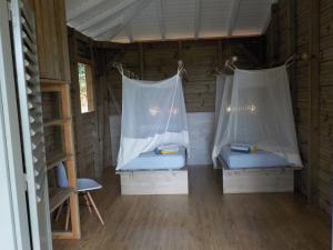 a room with two beds in a cabin at Nati Lodge - Bungalow Guadeloupe in Bouillante