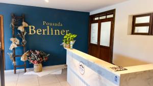 波梅罗迪Berliner Pousada的蓝色墙壁上挂着“puska behtar”的标志