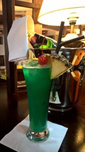 a green drink with a cherry on a table at Pension Masonic House in Loket