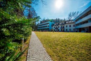 a brick walkway in a park next to a building at Hotel Murowanica in Zakopane