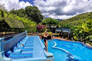 a woman standing on the steps of a swimming pool at Green Oasis Nha Trang Resort in Nha Trang