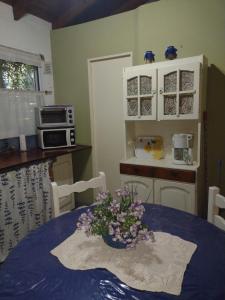 a kitchen with a table with a vase of flowers on it at Cabañas Caramelo in Villa Ventana