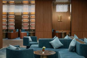 a hotel lobby with blue couches and a table at 西安明城墙永兴坊桔子水晶酒店 in Xi'an