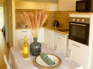 Η κουζίνα ή μικρή κουζίνα στο Pavillon Climatisé avec Piscine et Terrasse en Soleil, Proche Plage et Village - 2 Chambres + Mezzanine - FR-1-732-46