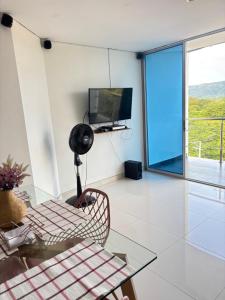 a living room with a glass table and a television at Apartamento Ricaurte hermosa vista in Ricaurte
