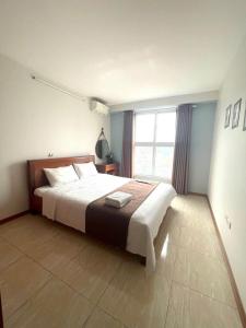 Un dormitorio con una cama grande y una ventana grande en Newlife Hạ Long -Homestay, en Ha Long