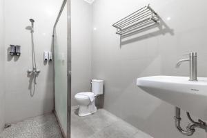 a white bathroom with a toilet and a sink at RedDoorz @ Soekarno Hatta Indah in Malang