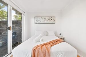 a bedroom with a bed and a window at 200m to the beach Pet friendly in Wamberal