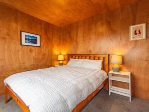 a bedroom with a bed and two lamps on tables at Mountain Haus - Ohakune Holiday Home in Ohakune