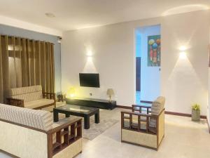 Una sala de estar con un sofá y un televisor. en The Cottage Ambuluwawa, en Gampola