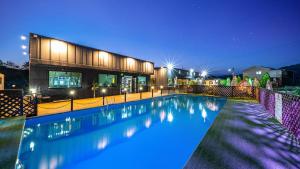 una piscina davanti a una casa di notte di Gapyeong Dogland Dog Caravan Glamping a Gapyeong