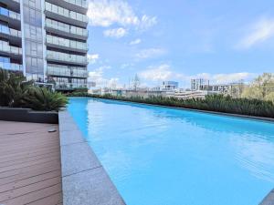 The Loft 3BDR, City Centre, Family-Friendly, King Bed, Massage Chair, Parking في كانبرا: حمام سباحة أزرق كبير أمام مبنى