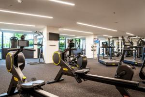 The Loft 3BDR, City Centre, Family-Friendly, King Bed, Massage Chair, Parking في كانبرا: صالة ألعاب رياضية بها العديد من أجهزة المشي والأجهزة في الغرفة