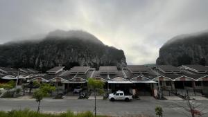 a white truck parked in a parking lot in front of a mountain at Small house surrounding with nature in Gua Musang