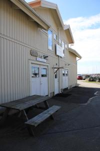 a wooden bench sitting in front of a building at Hamnhuset Björkö in Björkö