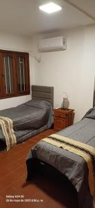 a bedroom with two beds and a fan at Departamento Peru y Borges in Santiago del Estero