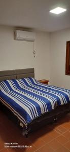 a bed with a blue and white striped comforter in a room at Departamento Peru y Borges in Santiago del Estero +16 photos