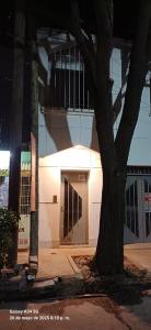 a tree in front of a building at night at Departamento Peru y Borges in Santiago del Estero