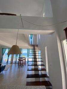 a staircase leading to a living room and a dining room at Villalola in Nosy Be