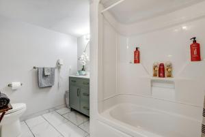 a white bathroom with a tub and a toilet at Luxury & private 3 bed unit kitchen wifi park mall in London +16 photos
