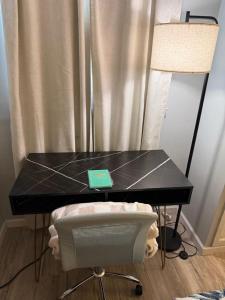 a black table with a chair in a room at Charming Long Island Room in Farmingdale