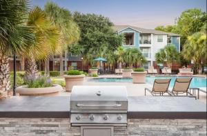 a grill in a courtyard with a pool at Apartment in Houston near NRG with Free Parking in Houston