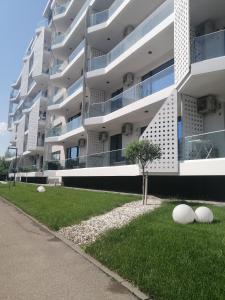 ein Gebäude mit weißen Bällen auf dem Gras davor in der Unterkunft MARIA Sea View Lake ON in Mamaia