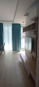 ein Wohnzimmer mit einem Flachbildfernseher an der Wand in der Unterkunft MARIA Sea View Lake ON in Mamaia