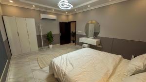 a bedroom with a large bed and a mirror at شقة مودرن فخمة غرفة نوم وصالة in Jeddah