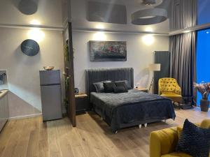 バトゥミにあるBlacksea apartamentのベッドルーム1室(ベッド1台、黄色い椅子付)