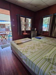 a bedroom with two beds and a fan in it at Mama O Chai Koh Tao in Koh Tao